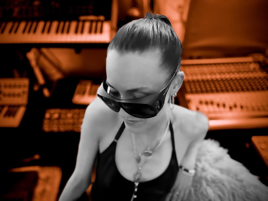 Michi∞ working in a recording studio surrounded by analog audio equipment